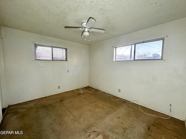 carpeted spare room with ceiling fan and a textured ceiling