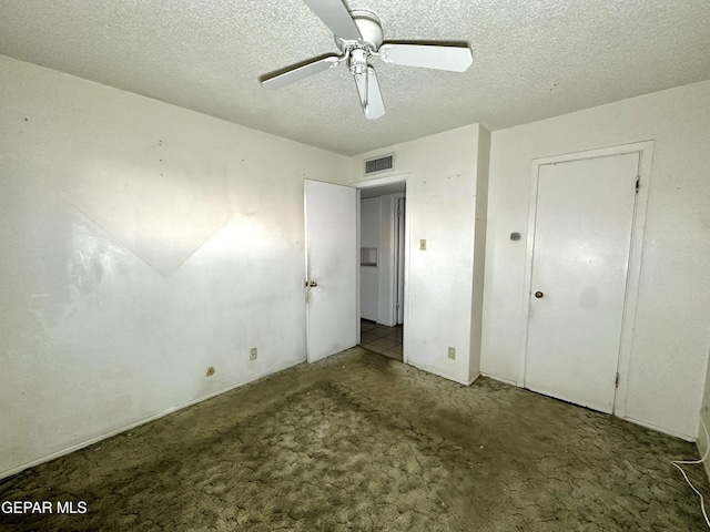 unfurnished bedroom featuring ceiling fan, carpet floors, and a textured ceiling