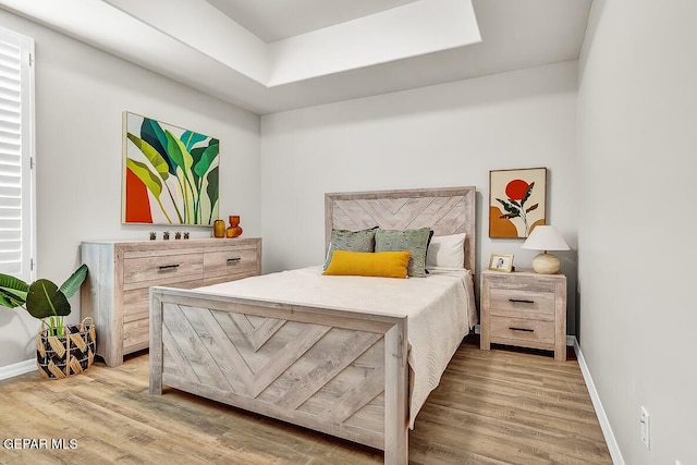 bedroom featuring a skylight and wood-type flooring