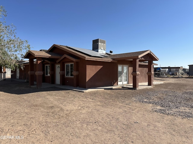 rear view of house with a patio area and solar panels