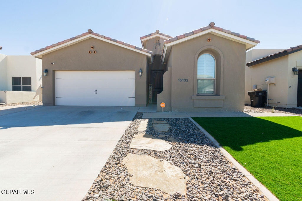 mediterranean / spanish-style home featuring a front yard and a garage