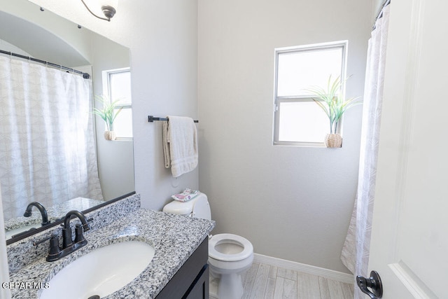 bathroom with vanity, hardwood / wood-style floors, toilet, and plenty of natural light