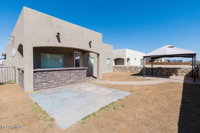 back of property featuring a gazebo and a patio area