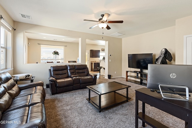 living room with ceiling fan and carpet