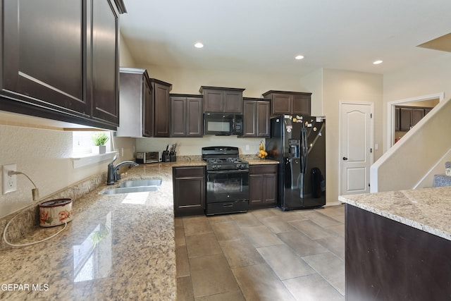 kitchen featuring dark brown cabinetry, light stone countertops, black appliances, and sink