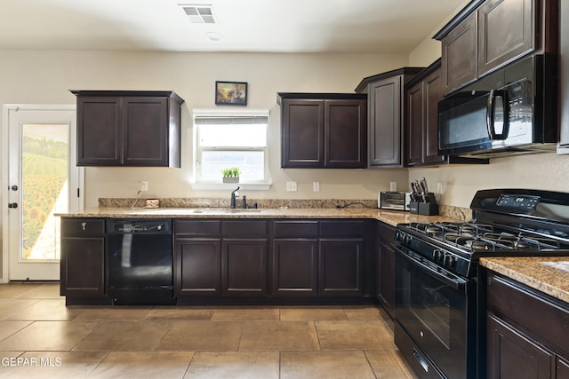 kitchen with dark brown cabinetry, black appliances, light stone countertops, and sink
