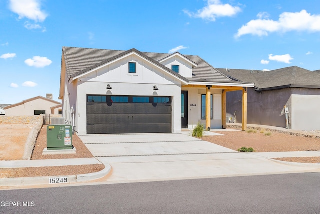 modern farmhouse with a tile roof, concrete driveway, a garage, board and batten siding, and stucco siding
