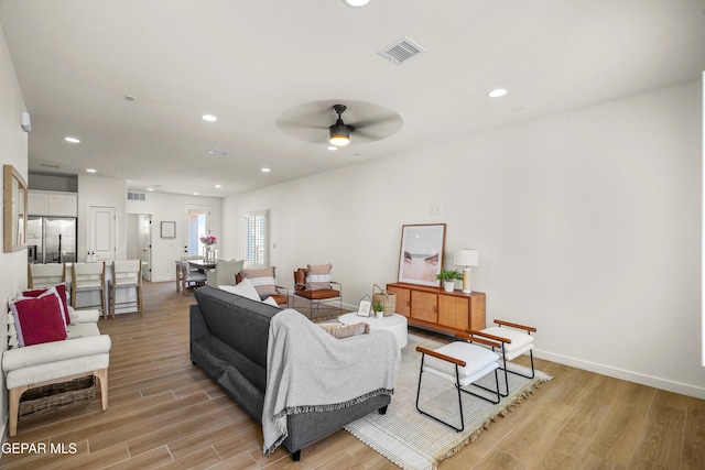 living room featuring recessed lighting, light wood-style floors, visible vents, and a ceiling fan