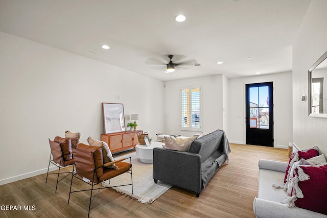 living area featuring baseboards, recessed lighting, a ceiling fan, and light wood-style flooring