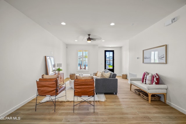 living room featuring ceiling fan, baseboards, light wood finished floors, and recessed lighting