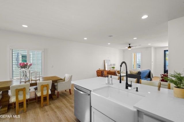 kitchen with light countertops, stainless steel dishwasher, ceiling fan, and a sink