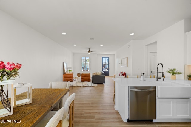 kitchen with a ceiling fan, a sink, light wood-type flooring, dishwasher, and white cabinets