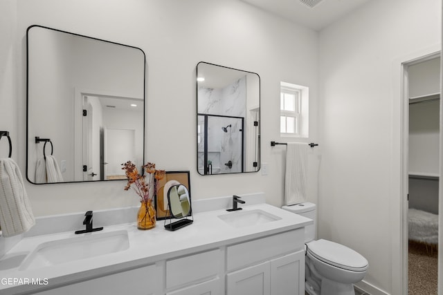 full bathroom featuring double vanity, toilet, a stall shower, and a sink