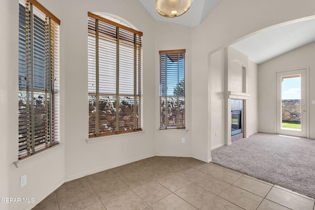 interior space with vaulted ceiling and light tile patterned floors