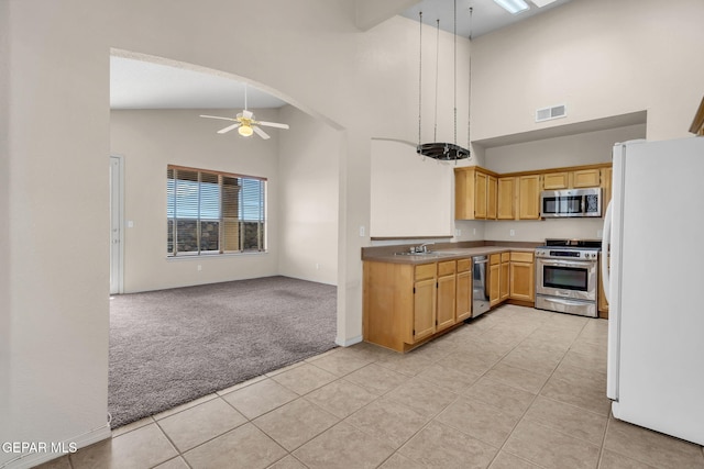 kitchen featuring stainless steel appliances, light colored carpet, sink, high vaulted ceiling, and ceiling fan