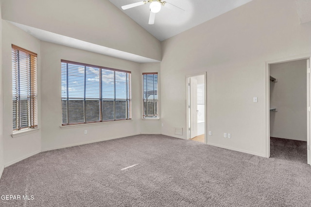 carpeted spare room featuring high vaulted ceiling and ceiling fan