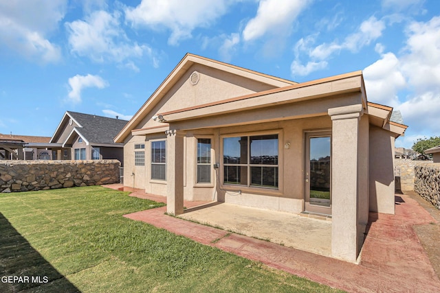 rear view of house with a yard and a patio area