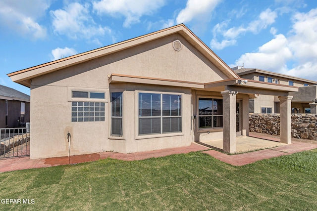 rear view of property with a lawn and a patio area