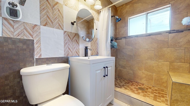 bathroom featuring a shower with shower curtain, vanity, toilet, and tile walls