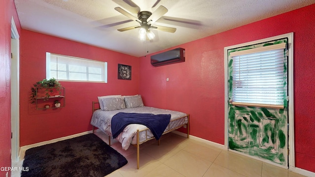 tiled bedroom with a wall mounted air conditioner, a textured ceiling, and ceiling fan