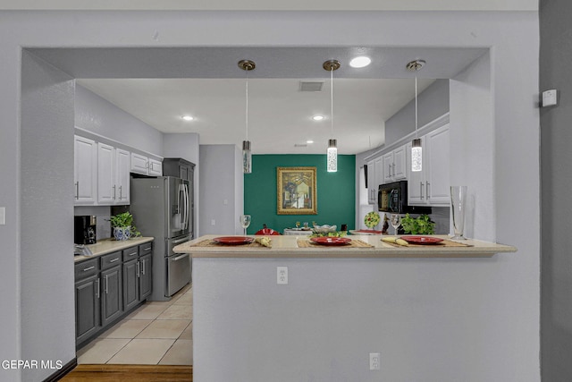 kitchen with white cabinets, stainless steel fridge, light wood-type flooring, and kitchen peninsula