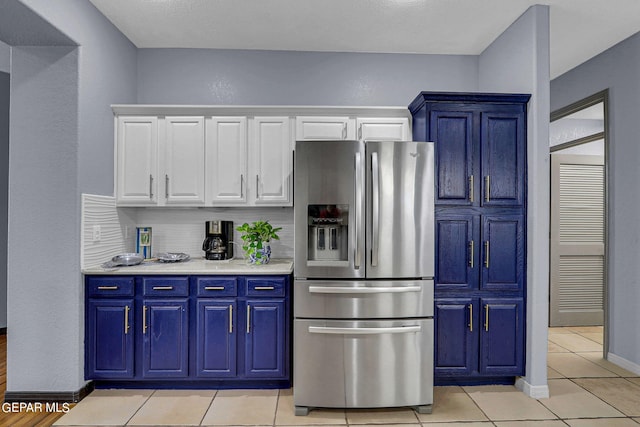 kitchen featuring white cabinetry, light tile patterned floors, stainless steel refrigerator with ice dispenser, and blue cabinets