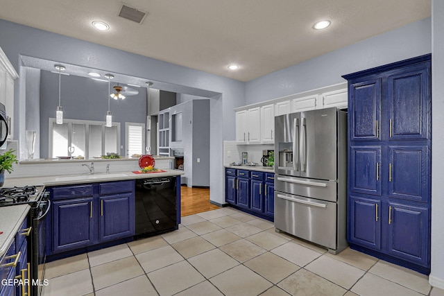 kitchen with blue cabinetry, white cabinets, light tile patterned flooring, and black appliances