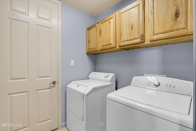 laundry room with cabinets, a textured ceiling, and independent washer and dryer