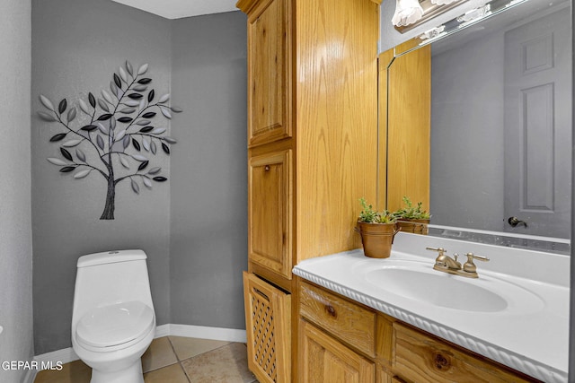 bathroom with toilet, vanity, and tile patterned floors