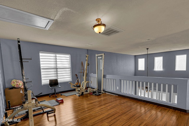 workout room with a textured ceiling and hardwood / wood-style flooring