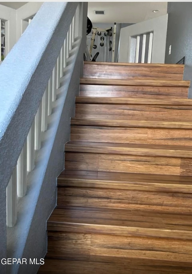 staircase with hardwood / wood-style floors