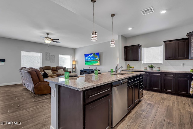 kitchen featuring dishwasher, dark brown cabinets, a kitchen island with sink, and pendant lighting