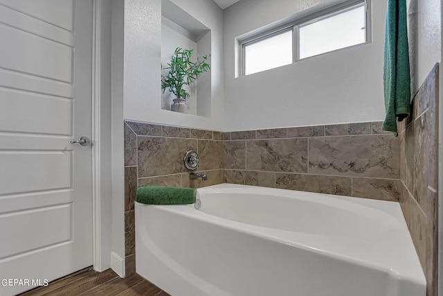 bathroom with hardwood / wood-style flooring and a bathing tub