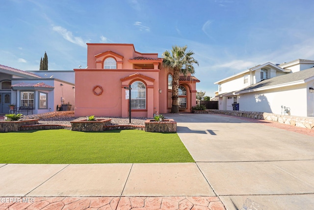 mediterranean / spanish-style house with a front lawn