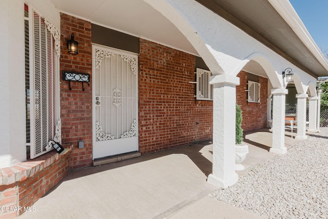 view of exterior entry featuring covered porch