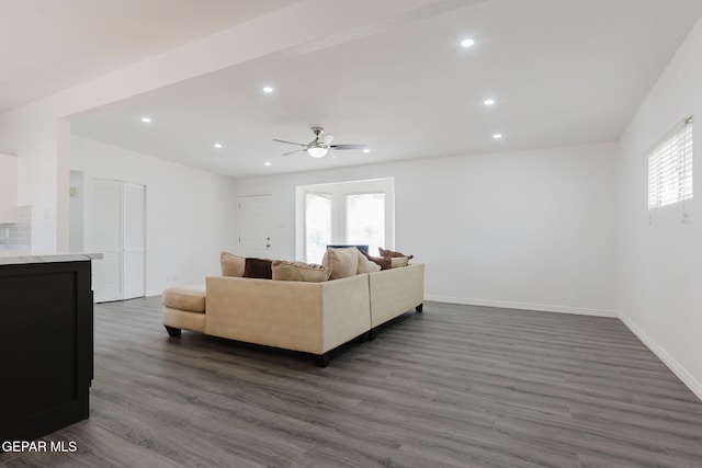 living room featuring ceiling fan and dark hardwood / wood-style floors