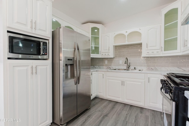 kitchen featuring sink, appliances with stainless steel finishes, light wood-type flooring, and white cabinets