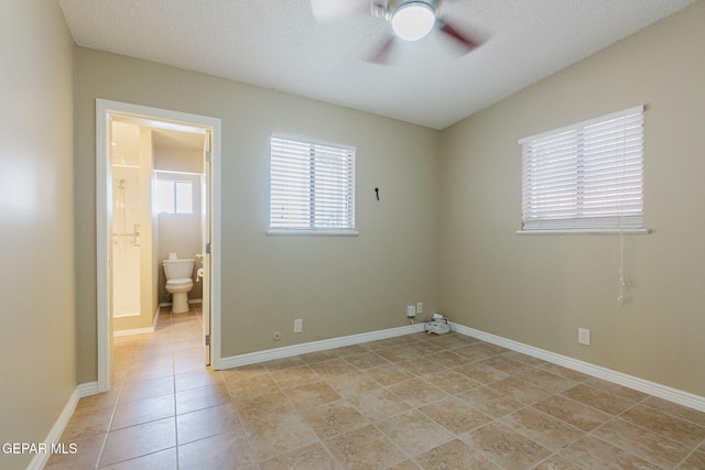 tiled empty room with a textured ceiling and ceiling fan