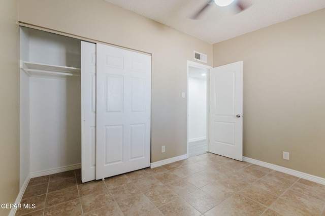 unfurnished bedroom featuring light tile patterned floors, a closet, and ceiling fan