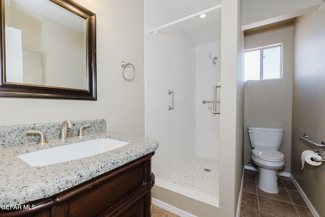 bathroom featuring vanity, tiled shower, toilet, and tile patterned floors