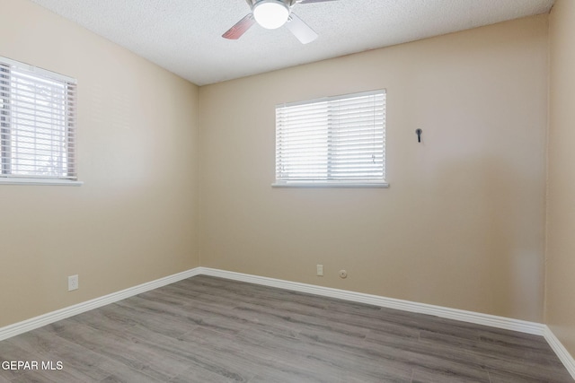 empty room featuring a textured ceiling, wood-type flooring, and ceiling fan