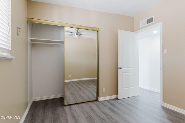 unfurnished bedroom with hardwood / wood-style flooring and a closet