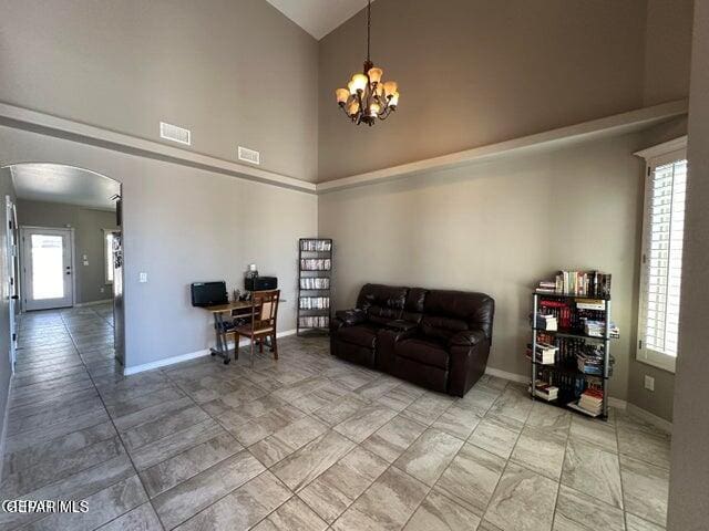 living room with high vaulted ceiling, a healthy amount of sunlight, and a chandelier