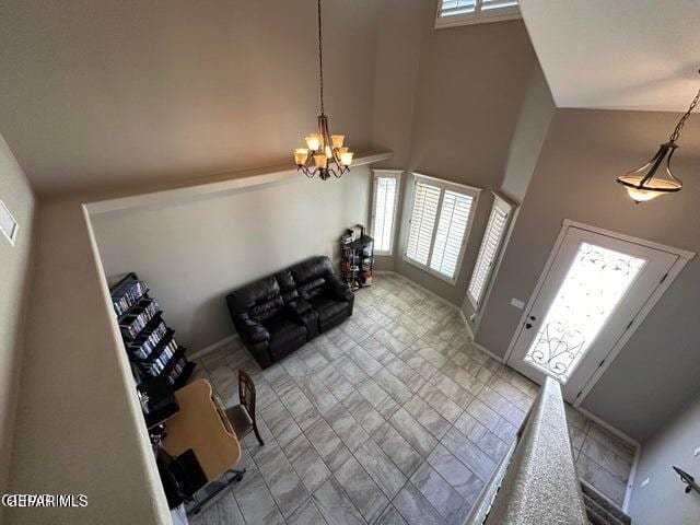 living room featuring a healthy amount of sunlight, a notable chandelier, and high vaulted ceiling