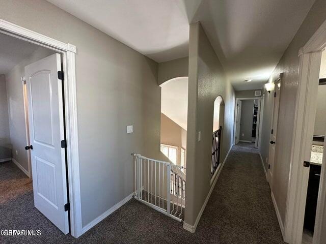 12419 Winners Cir, El Paso, TX 79928 - hall with dark carpet, arched walkways, and baseboards