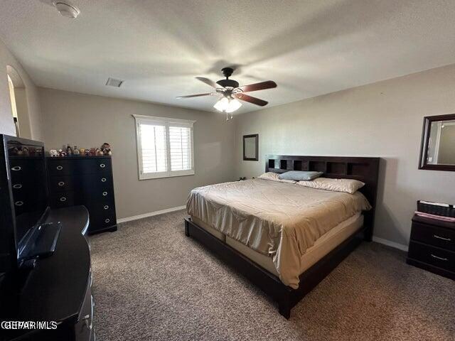 carpeted bedroom featuring a textured ceiling and ceiling fan