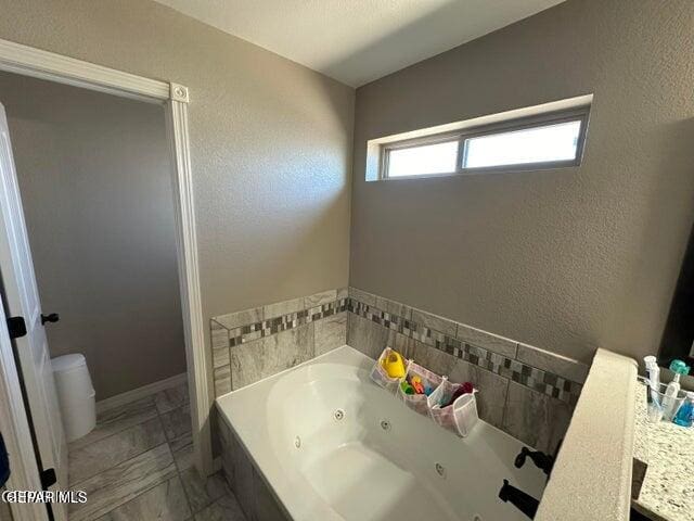 bathroom with vanity and a tub