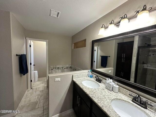 bathroom featuring vanity, a textured ceiling, and an enclosed shower