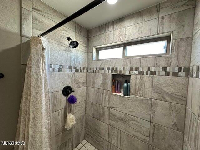 bathroom with curtained shower and plenty of natural light