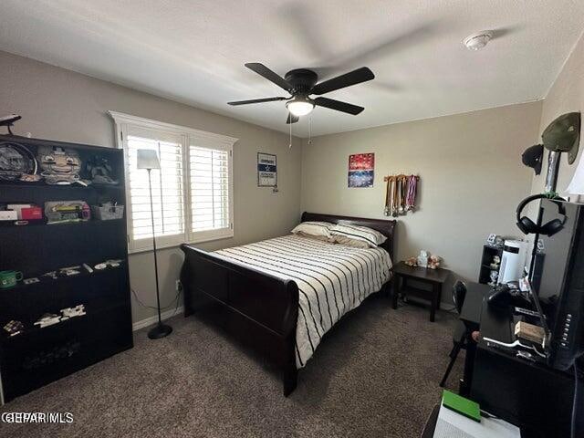 bedroom with ceiling fan and dark colored carpet